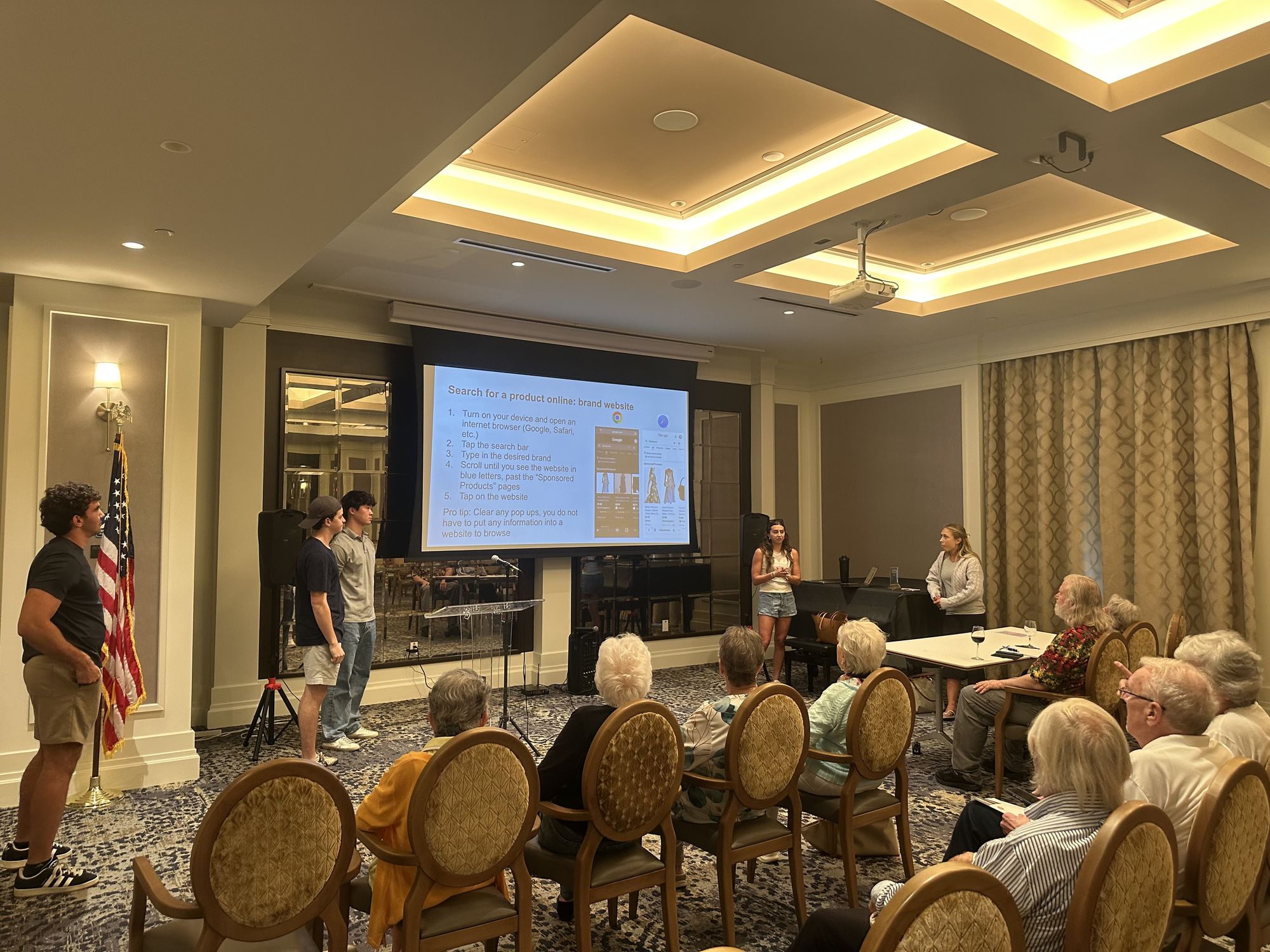 Tech Connect members presenting a slide about searching online to a seated audience of older adults.